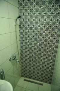 eine Dusche im Bad mit Fliesenboden in der Unterkunft Kuća za odmor ''S'' in Mladenovo