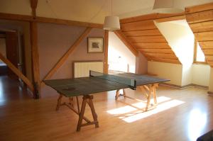 a ping pong table in the middle of a room at Maison de la Combe des Cives in Chapelle-des-Bois