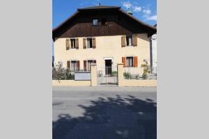 ein großes weißes Haus mit braunem Dach in der Unterkunft Appartement à la nuitée in Marnaz