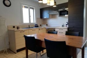 eine Küche mit einem Holztisch und schwarzen Stühlen in der Unterkunft Appartement à la nuitée in Marnaz + 8 Fotos