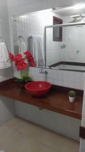 a bathroom with a red sink and a mirror at Solar Pipa Flats in Pipa