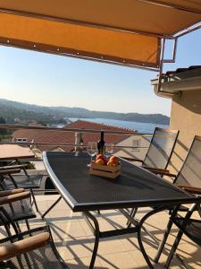 a table with a bottle of wine and fruit on a balcony at Apartments Mare in Korčula