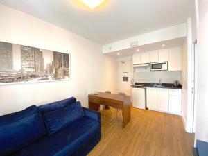 a living room with a blue couch and a kitchen at Apartamento conforto - Itaim Bibi in Sao Paulo