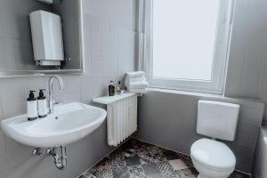 ミュンスターにあるStylisches Münster City-Apartment 83 m²の洗面台とトイレを備えた白いバスルーム +15枚の写真