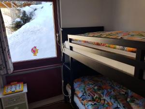 エンゲルベルクにあるApartment Fellenrüti 82 by Interhomeのベッドルーム1室(二段ベッド2台付)、雪の窓が備わります。