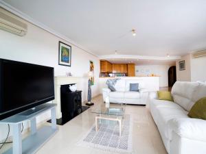 sala de estar con sofá blanco y TV en Apartment Villa Marina Golf-1 by Interhome, en Altea la Vieja