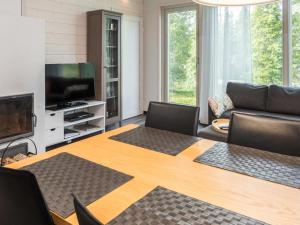 ein Wohnzimmer mit einem Tisch mit Stühlen und einem TV in der Unterkunft Holiday Home Villa vuosseli c 1 by Interhome in Aikkila