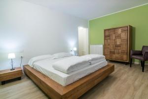1 dormitorio con 1 cama grande y 1 silla en Albergo Berna, en Erbezzo