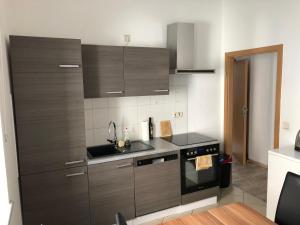 a kitchen with brown cabinets and a sink and a stove at Ruhige EG Wohnung bei der Burg in Kröllwitz