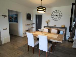 a dining room with a wooden table and white chairs at Apartment La Perla di Laveno by Interhome in Laveno-Mombello