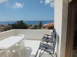 balcón con mesa, sillas y vistas al océano en Villa Isolde, en Triscina