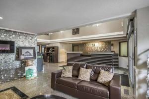 a living room with a leather couch and a bar at Quality Inn & Suites Yorkton in Yorkton