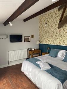 新港的住宿－Three Bishops Inn，一间卧室设有两张床,墙上配有电视。