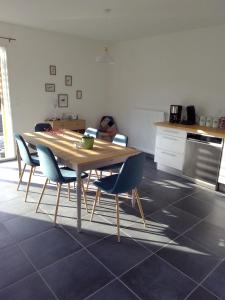 cocina con mesa de madera y sillas en La Masquénada 85 m2, neuve, moderne, confort avec grand garage en Cublac