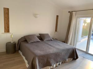 ein Schlafzimmer mit einem Bett und einem großen Fenster in der Unterkunft Villa Ponte Vista in Castro Marim