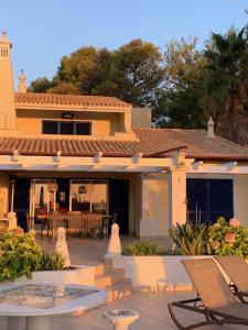 ein Haus mit einer Terrasse, einem Tisch und Stühlen in der Unterkunft Villa Ponte Vista in Castro Marim