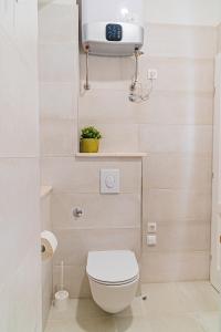 a bathroom with a toilet and a clock on the wall at Apartman Lena Centar in Bol