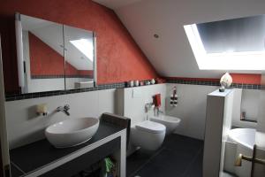 a bathroom with two toilets and a sink and a mirror at Wiegmann´s Ferienhaus in Mechernich