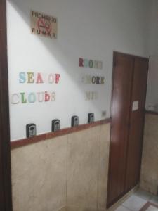 a bathroom with a wall of posters on the wall at Pensión Sea of Clouds in Las Palmas de Gran Canaria