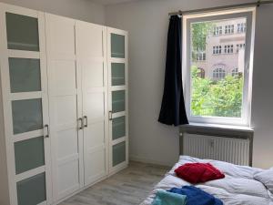 a bedroom with white cabinets and a bed and a window at Ruhige Wohnung bei der Burg im OG1 in Kröllwitz