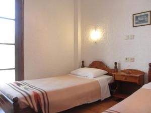 a bedroom with two beds and a table and a window at Thamiris Apartments in Kalyves