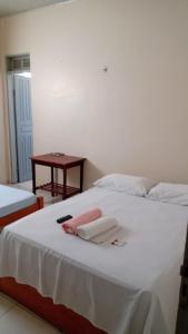 um quarto com uma cama branca com duas toalhas em Hotel Rilton em Carolina