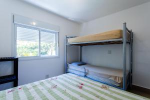 a bedroom with two bunk beds and a window at Condominio Vilabela da Princesa in Ilhabela