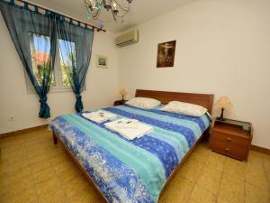 a bedroom with a bed with two towels on it at Holiday Home Villa Palma by Interhome in Postira