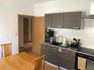 a kitchen with a sink and a table with a microwave at Ruhige Wohnung bei der Burg im OG2 in Kröllwitz