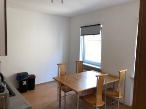 a dining room with a wooden table and chairs at Ruhige Wohnung bei der Burg im OG2 in Kröllwitz +3 photos