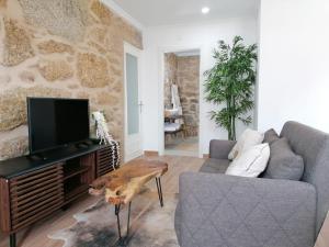 - un salon avec un canapé et une télévision dans l'établissement Cantinho D'Aldeia, à Guarda