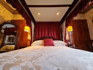 a bedroom with a large bed with red curtains at Bluebell House in Inverness