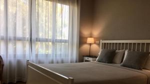 um quarto com uma cama e uma grande janela em MD Modern Hotel - Jardines em Valência