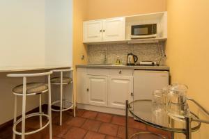 una pequeña cocina con armarios blancos y microondas en El Patio Miraflores en Lima