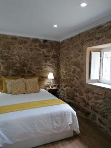 a bedroom with a large bed and a window at Cantinho D'Aldeia in Guarda