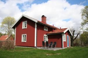una casa roja con una mesa y sillas frente a ella en Stuga Linnebråten, en Värnamo