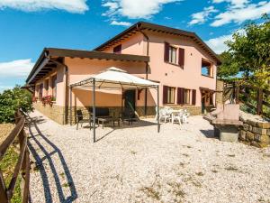 ApecchioにあるCharming Farmhouse in Apecchio Marche with Private Terraceの傘付きの家の外観