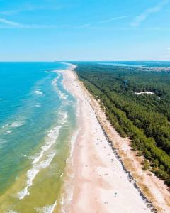 an aerial view of a beach with trees and the ocean at Martina Rooms&Restaurant Łeba in Łeba
