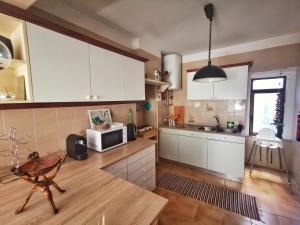 a kitchen with white cabinets and a microwave at Sintra Central Flat in Sintra