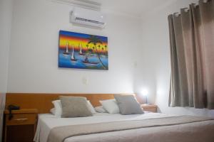 a bedroom with two beds and a painting on the wall at Pousada Vale Del Sol in Bombinhas +103 photos