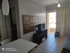 a living room with a table and a tv at Serra Park Flat 420 in Rio Quente