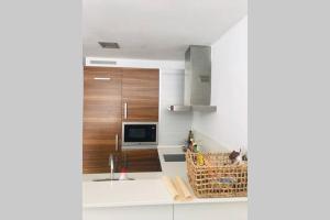 een keuken met witte werkbladen en houten kasten bij Precioso loft en el centro in A Coruña
