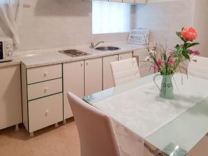uma cozinha com uma mesa com um vaso de flores em Apartment Danica-1 by Interhome em Peroj