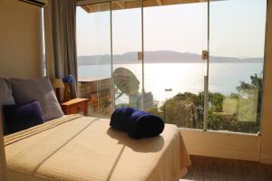 a bedroom with a bed with a view of the ocean at Sobrado Bela Vista in Bombinhas