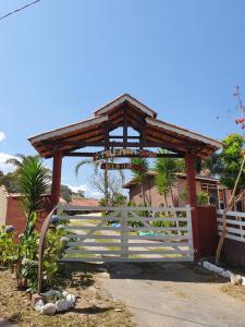 a wooden gate in front of a house with a fence at Pousada Beija flor in Extrema