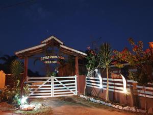 a white gate in front of a house at night at Pousada Beija flor in Extrema