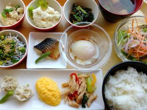 einen Tisch mit Schalen verschiedener Arten von Lebensmitteln in der Unterkunft Sotetsu Fresa Inn Fujisawa Shonandai in Fujisawa
