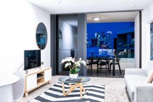 a living room with a couch and a table at Opera Apartments South Brisbane in Brisbane