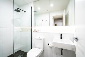 a white toilet sitting next to a sink in a bathroom at Opera Apartments South Brisbane in Brisbane
