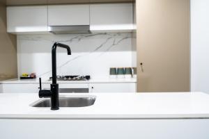 a white sink sitting under a white counter top in a kitchen at Opera Apartments South Brisbane in Brisbane